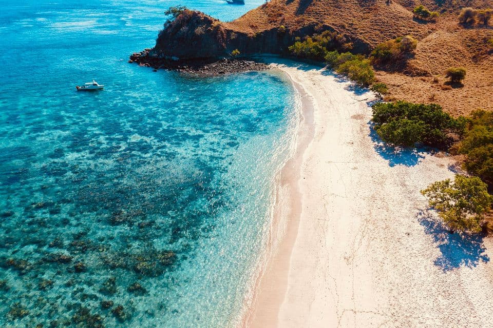 Pink Beach and dry hills in Komodo National Park, Indonesia