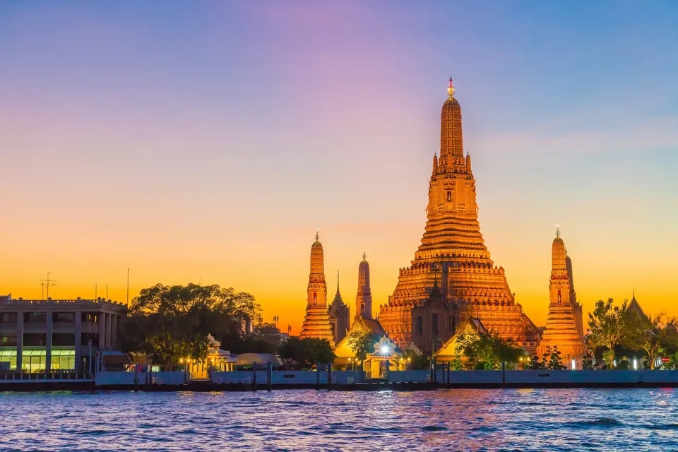 Wat Arun at sunset beside the Chao Phraya River in Bangkok, Thailand
